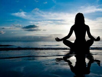 Haciendo yoga a la vera del mar