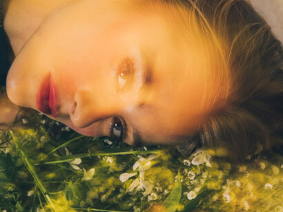 Bathed in light, a model rests close to earth