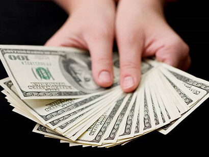 A person's hand showcasing a fan of banknotes