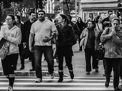Witness the pulse of society in a dynamic photograph of people leisurely walking along a well-trodden pedestrian path during the day, capturing the essence of community life in motion