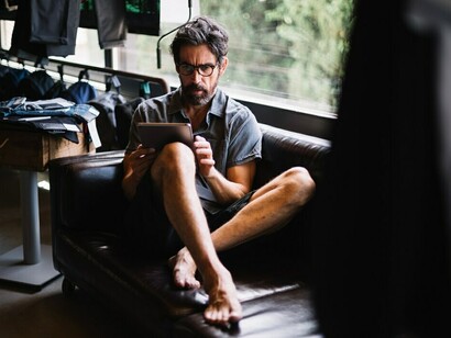 A man with a tablet, working from home, embracing the freedom of a flexible freelance schedule