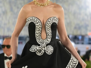 Anne Hathaway in Michael Kors Collection, wearing a gown featuring floral detailing and a peace-inspired motif during the 2026 Met Gala