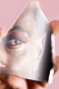 Persona de género fluido reflejada en un fragmento de espejo