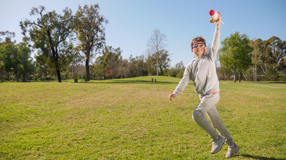Menino brinca com seu foguete no parque