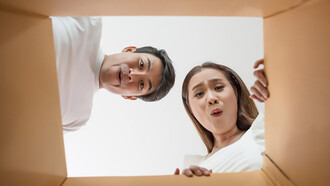 A couple opens a box together, excitedly examining the product inside