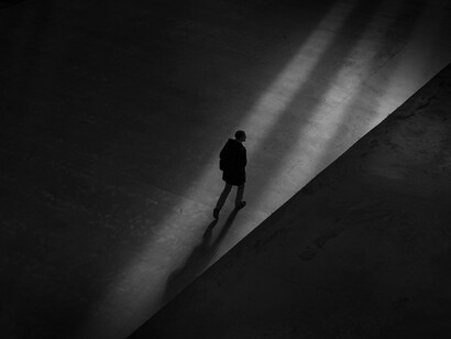 Hombre camina solo por la calle entres sombras