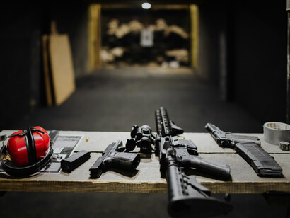 Firearms aligned neatly, reflecting the commercialisation of warfare in modern politics