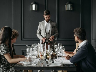 Diners participating in a sophisticated tasting experience, reflecting the growing appeal of aspirational consumption