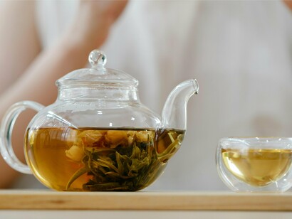 A glass teapot of herbal tea steeps calmly, offering a fragrant ritual to soothe anxiety at the start of the day