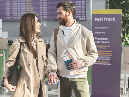 A smiling couple with passports and documents at the airport, symbolizing skilled migration and brain drain as they prepare to move abroad for new opportunities