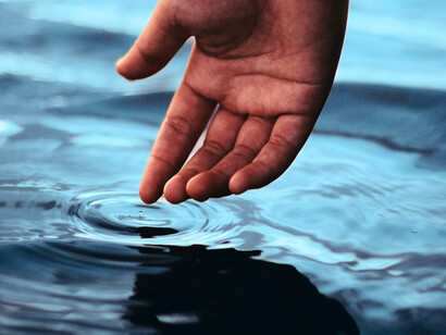 Le doigt effleurant l'eau symbolise l'incompréhension de l'énigme de la continuité entre les strates naturelles, mettant en évidence la difficulté de saisir cette relation fluide et continue