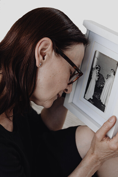 The woman is sad when she looks at a photo of her husband