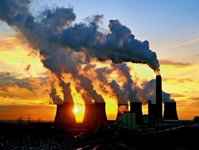 El humo de las chimeneas de una fábrica al atardecer