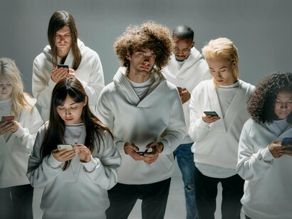 Grupo de pessoas atentas ao celular. A exposição constante a comparações de estilos de vida nas redes sociais tem sido associada a sentimentos de inadequação e baixa autoestima


