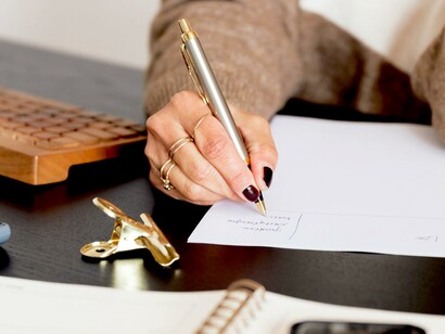 Mulher faz lista à mão em papel