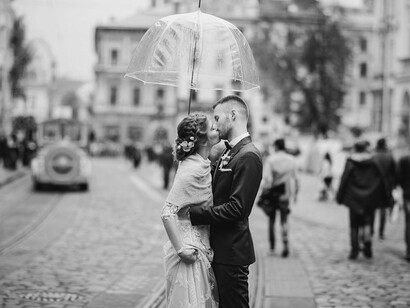 A quiet kiss under one umbrella proves that the right destination is more about feeling than forecast