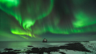 Aurora boreal en las playas de Reynisdrangar