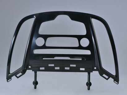 A plastic car dashboard frame that mounts over/around components like air vents, the instrument cluster, or center controls