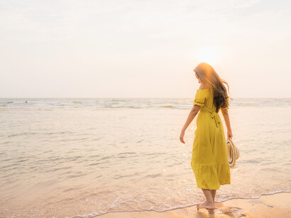 A woman framed by the colours of sunset, capturing the harmony between human emotion and nature’s rhythms