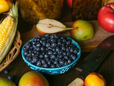 Frutas frescas e vegetais dispostos sobre uma mesa destacam a diversidade dos alimentos naturais. Nutrientes e compostos bioativos presentes nesses alimentos participam de processos associados à regulação epigenética