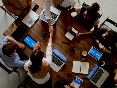 A group of people sitting around a table, engaged in discussion and collaborative work