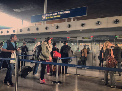 Passengers waiting in line at the airport for check-in, going through border security, visa control, and customs procedures