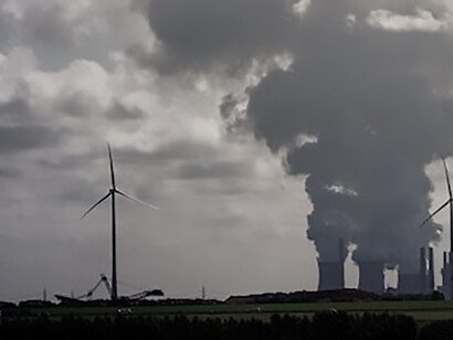 Capture the visual of nuclear plants and fossil fuel facilities emitting dense white plumes of smoke