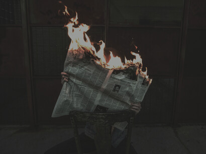 A newspaper on fire representing fake news