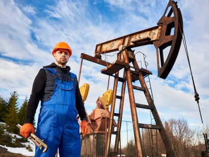 An energy worker standing near an oil infrastructure, symbolising the geopolitical importance of reliable energy supplies