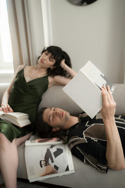 Uomo e donna annoiati con libri sul divano