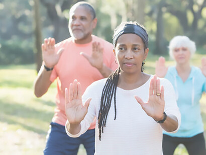 Discover the vitality of a multi-ethnic group of seniors engaging in a Tai Chi lesson—an enriching exercise fostering holistic well-being and active aging