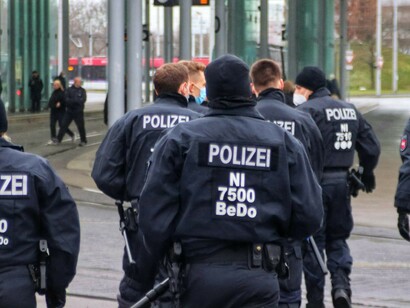 A group of police officers patrols the street, moving in unison, Germany