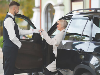 Indulge in high-end luxury experiences as a parking valet expertly assists a VIP client in parking her car at exclusive events