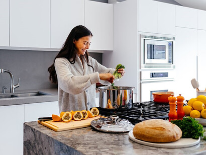 In the heart of the kitchen, a woman's radiant smile adds an extra dash of warmth to her culinary endeavors