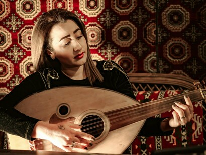 A woman performing with an oud in hand, reflecting the emotional depth of Moroccan folk music