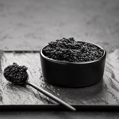 A bowl of black caviar elegantly presented with spoons and a ladle