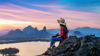 Tourist sitting on Phu sub lek viewpoint at sunset Lopburi Thailand