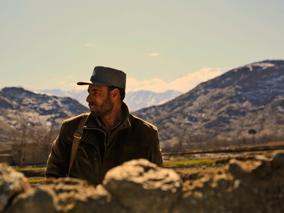 In a valley or a village, a soldier stands in wait in Afghanistan