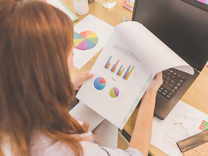 Discover a woman deeply engaged at her desktop, meticulously exploring diagrams and charts, emblematic of fashion data analysis, consumer behavior insights, and data visualization techniques crucial for understanding fashion trends