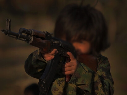 A child in Syria, forced to use weapons to fight