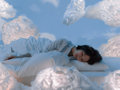 Clouds float around the woman asleep