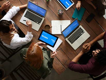 A group of people seated around a table, discussing, working, and networking