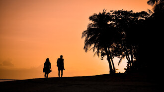 Silueta de una pareja caminando por la playa Dumaluan, Provincia de Bohol, Filipinas