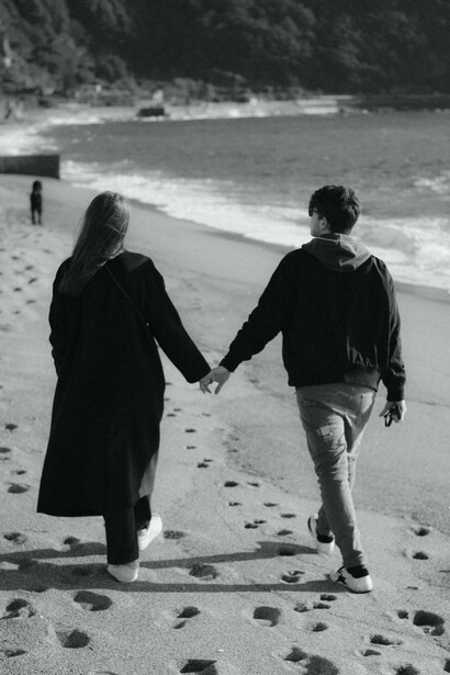 Coppia passeggia sulla spiaggia mano nella mano