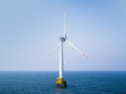 A solitary offshore wind turbine rising above the calm sea