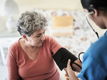 A Latin American woman receives a medical exam at home as part of community health and nutrition projects in the Global South