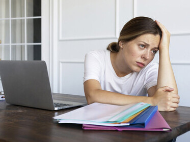 Woman with a desk job sitting all day, showing signs of fatigue and poor posture