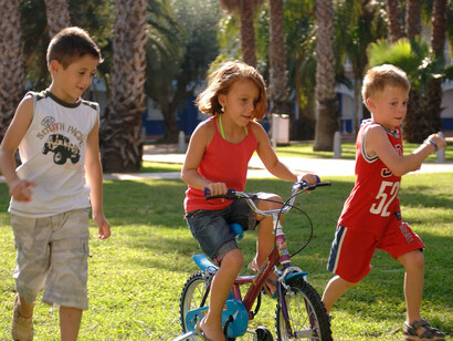 Niños corriendo y montando en bicicleta en el parque