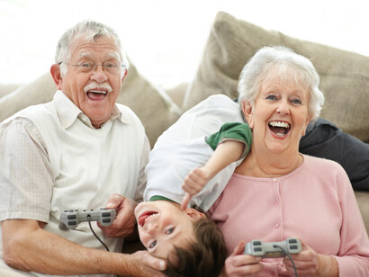 Abuelos jugando a la consola con su nieto