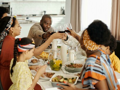 A family enjoying a shared meal at the table, expressing warmth, connection, and cultural food traditions